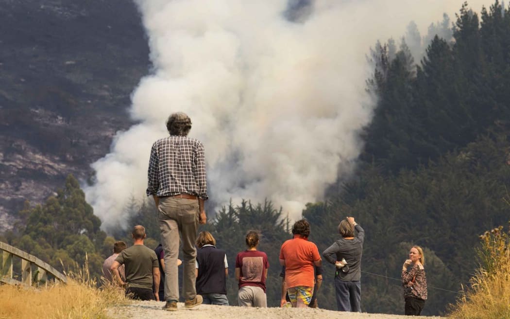 Locals watch one of the fires on the Port Hills.