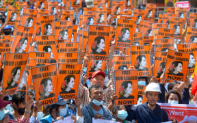 Protesters hold posters with the image of detained civilian leader Aung San Suu Kyi during a demonstration against the military coup in Naypyidaw on February 28, 2021.