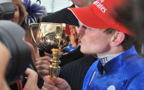 English jockey Ryan Moore kisses the trophy after winning the Melbourne Cup with Germany's Protectionist.