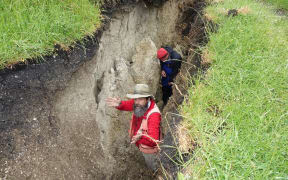 Russ Van Dissen and Jamie Howarth take samples from a giant chasm created by the quake on a Ward farm.