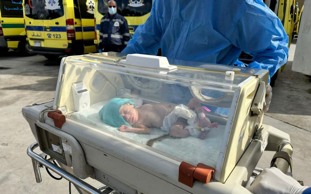 Egyptian medics wheel a premature Palestinian baby evacuated from Gaza to an ambulance on the Egyptian side of the Rafah border crossing with the Gaza Strip, on 20 November, 2023, amid the ongoing battles between Israel and the militant group Hamas. T