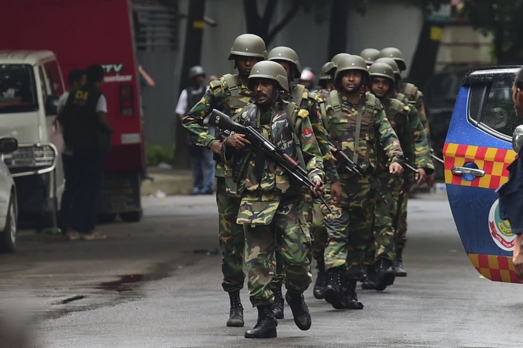 Bangladeshi army soldiers patrol a street during a rescue operation.