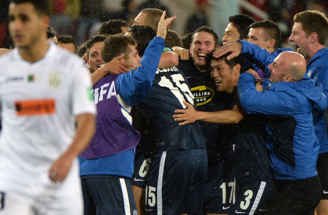 Auckland City's players celebrate with coaching staff after defeating ES Setif during their 2014 FIFA Club World Cup quarter-final.