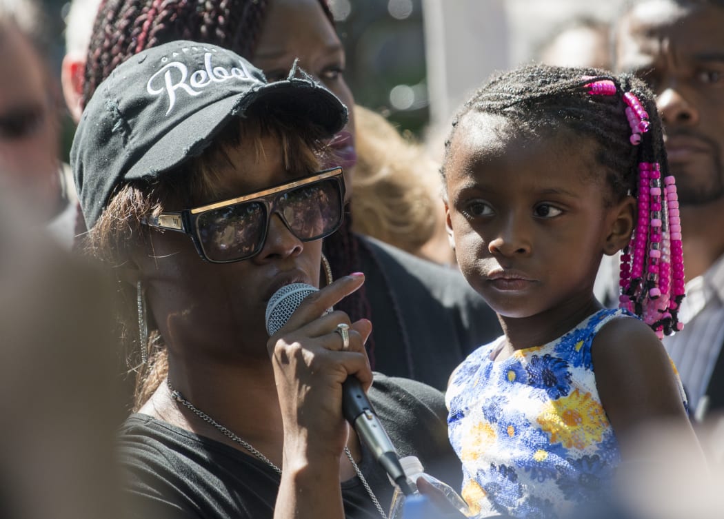 Diamond Reynolds, holding her daughter, talks to protesters after her boyfriend was shot by police.