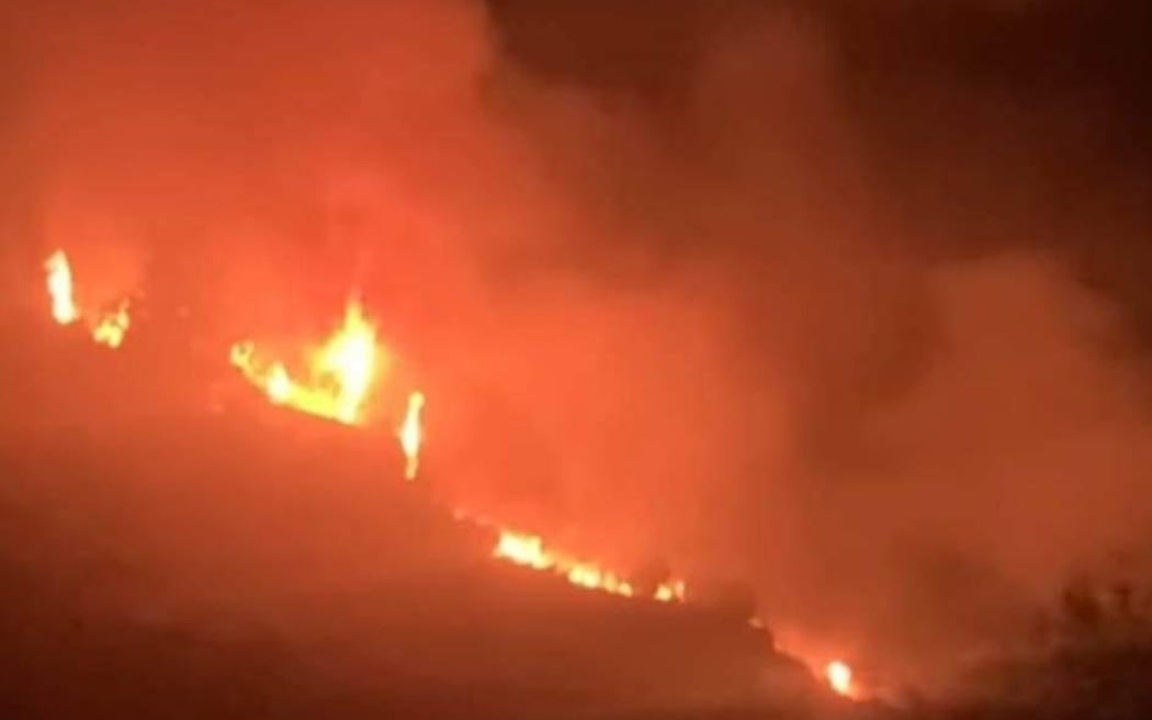 Firefighters battle blaze sparked by fireworks and threatening homes