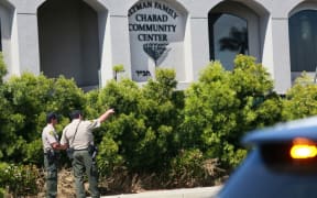 San Diego Sheriff deputies look over the Chabad of Poway Synagogue after a shooting.