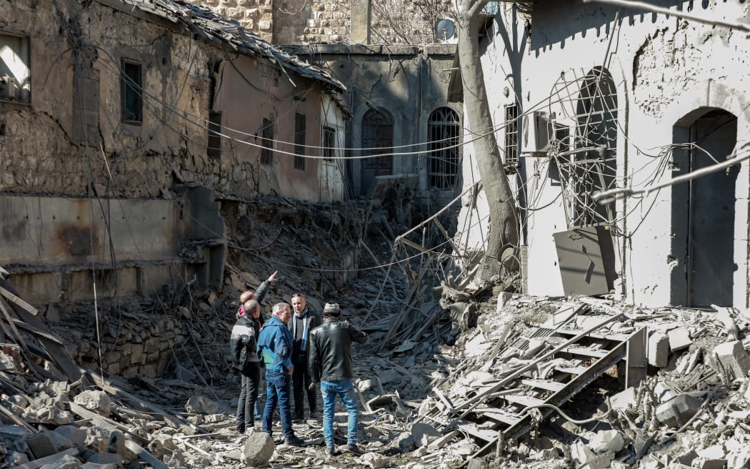 People inspect damage in the aftermath of an air strike that hit the medieval Citadel of Damascus on 19 February, 2023. The air strike on Syria's capital killed 15 people early on February 19 and badly damaged a building in a district home to several state security agencies, according to the UK-based Syrian Observatory for Human Rights.