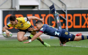 Hurricanes winger Kobus van Wyk scores in the tackle of Sio Tomkinson