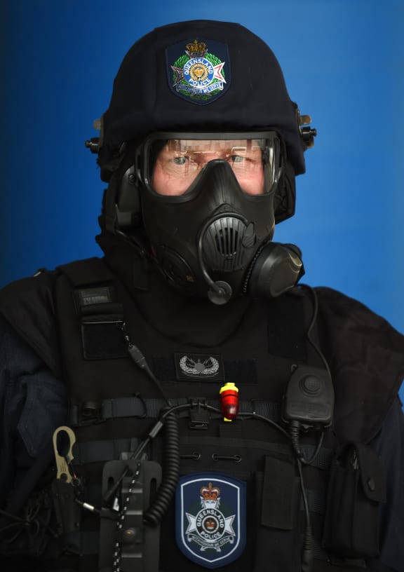 A Queensland police officer in tactical gear poses for a photo during a vehicle search demonstration ahead of the G20 meeting in Brisbane.