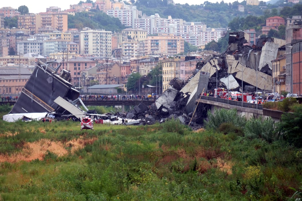 Another angle of the collapsed bridge shows rescuers scouring through the wreckage and people gathered around the scene.