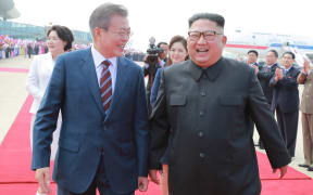 North Korean leader Kim Jong Un (R), welcomes South Korean President Moon Jae-in during a ceremony at Pyongyang airport.