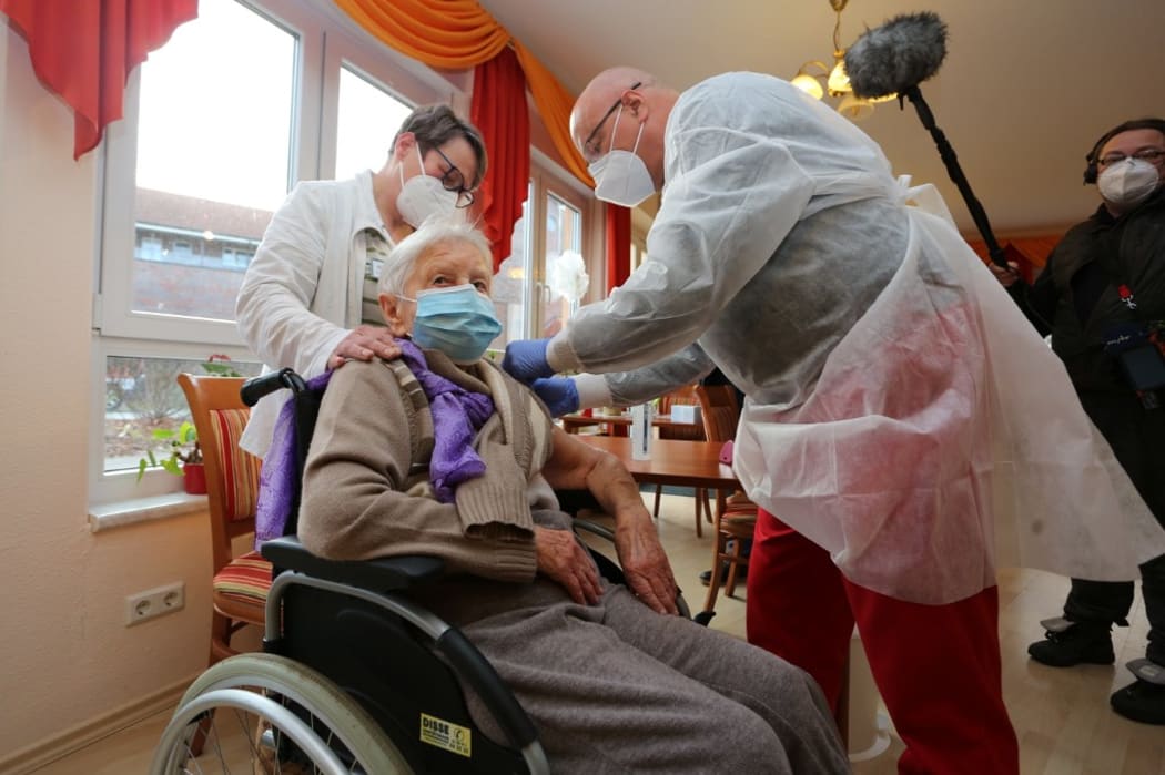 Edith Kwoizalla, 101 years old, receives the first vaccination against the novel coronavirus COVID-19 by Pfizer and BioNTech from Doctor  Bernhard Ellendt (R) in a senior care facility in Halberstadt (Seniorenzentrum Krueger), central northern Germany, on December 26, 2020.