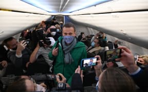 Russian opposition leader Alexei Navalny walks to take his seat in a Pobeda airlines plane heading to Moscow before take-off from Berlin Brandenburg Airport (BER) in Schoenefeld, southeast of Berlin, on 17 January, 2021.