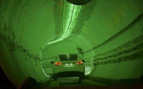 A modified Tesla Model X drives into the tunnel entrance before an unveiling event for the Boring Co.