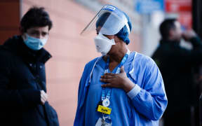 A medic wearing a face mask and visor stands outside the emergency department of the Royal London Hospital in London, England, on January 9, 2021.