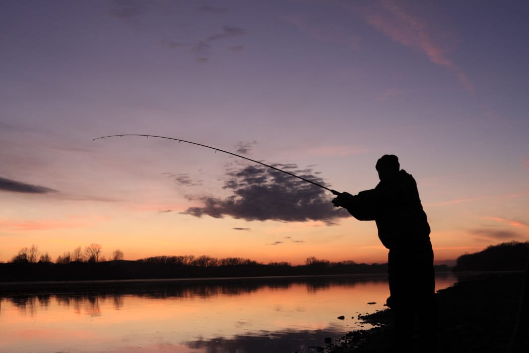 A file photo shows a man casting his line into a river.