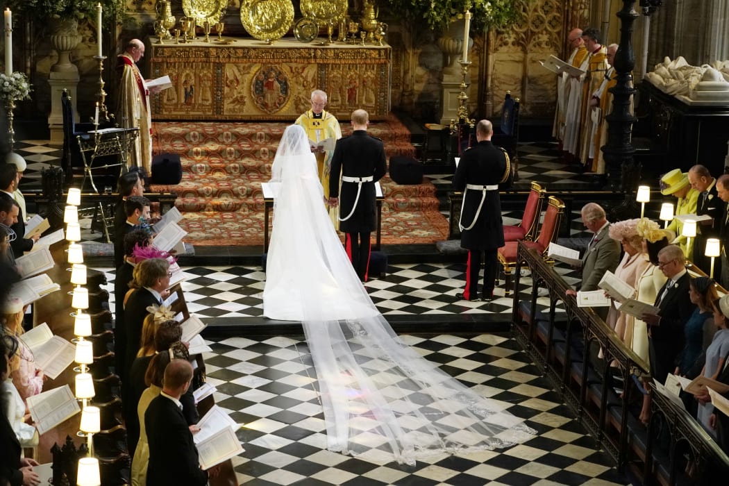 Britain's Prince Harry, Duke of Sussex (R) and US actress Meghan Markle (L) stand at the altar together before Archbishop of Canterbury Justin Welby (C) in St George's Chapel, Windsor Castle, in Windsor, on May 19, 2018 during their wedding ceremony. / AFP PHOTO / POOL / Owen Humphreys