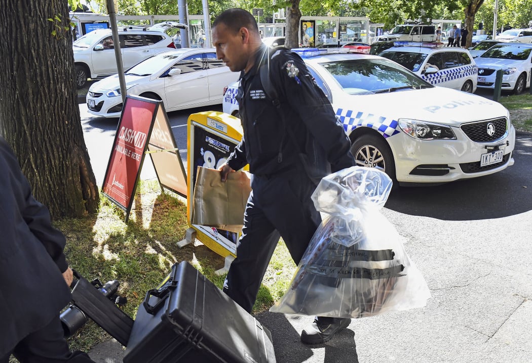 A Victoria Police forensic officer carries items to be loaded into a trailer outside the Italian consulate in Melbourne on January 9, 2019. Australian police are investigating the delivery of suspicious packages sent to foreign embassies and consulates in Melbourne and Canberra.