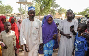 A girl released by Boko Haram walks with her father in Dapchi.