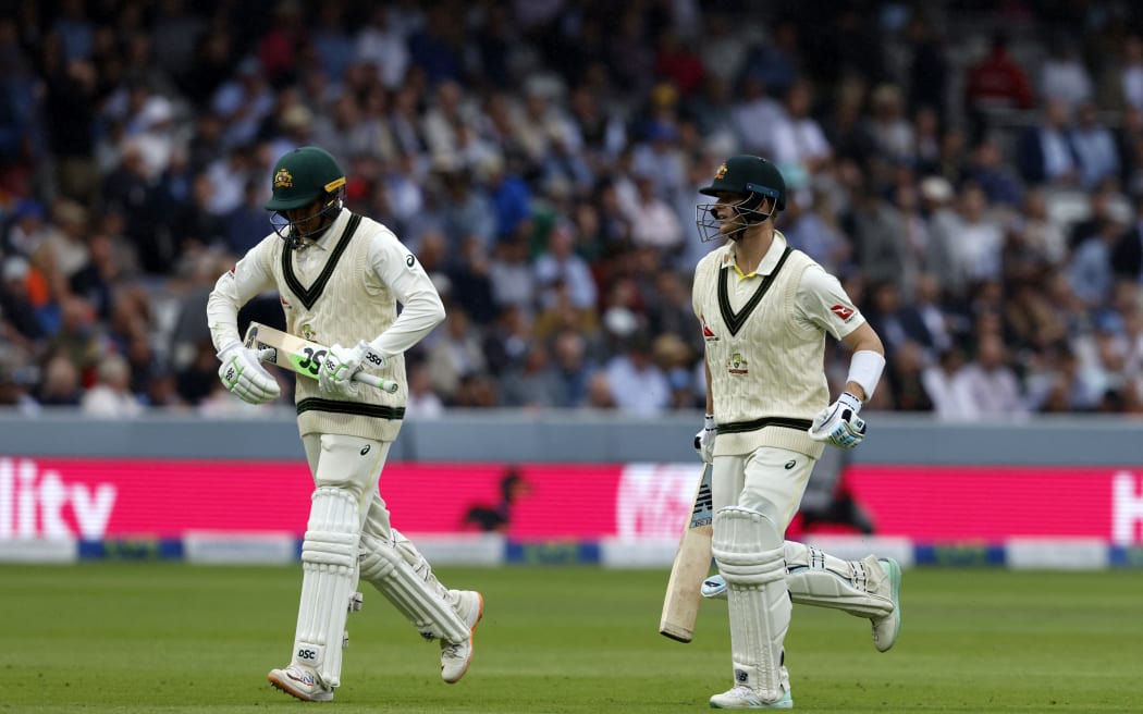 Australia's Usman Khawaja (L) and Australia's Steven Smith (R) run from the field as rain stop play on day three of the second Ashes cricket Test match between England and Australia at Lord's cricket ground in London on June 30, 2023. (Photo by Ian Kington / AFP) / RESTRICTED TO EDITORIAL USE. NO ASSOCIATION WITH DIRECT COMPETITOR OF SPONSOR, PARTNER, OR SUPPLIER OF THE ECB