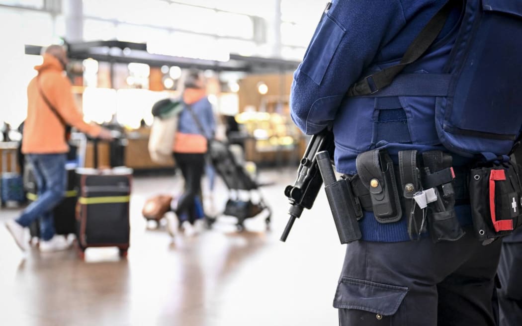 A policeman stands guard in the departure hall of Brussels Airport, in Zaventem on October 17, 2023, after the suspected perpetrator of the attack in Brussels was shot dead during a police intervention. The suspect in the Brussels killing of two Swedish football fans was shot and fatally wounded by police during his arrest on October 17, 2023, officials said. (Photo by DIRK WAEM / BELGA / AFP) / Belgium OUT