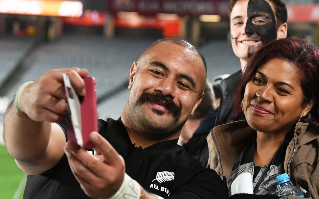 Karl Tu'inukuafe poses for a selfie with All Blacks fans.