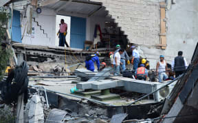 People search a collapsed building in Mexico City.