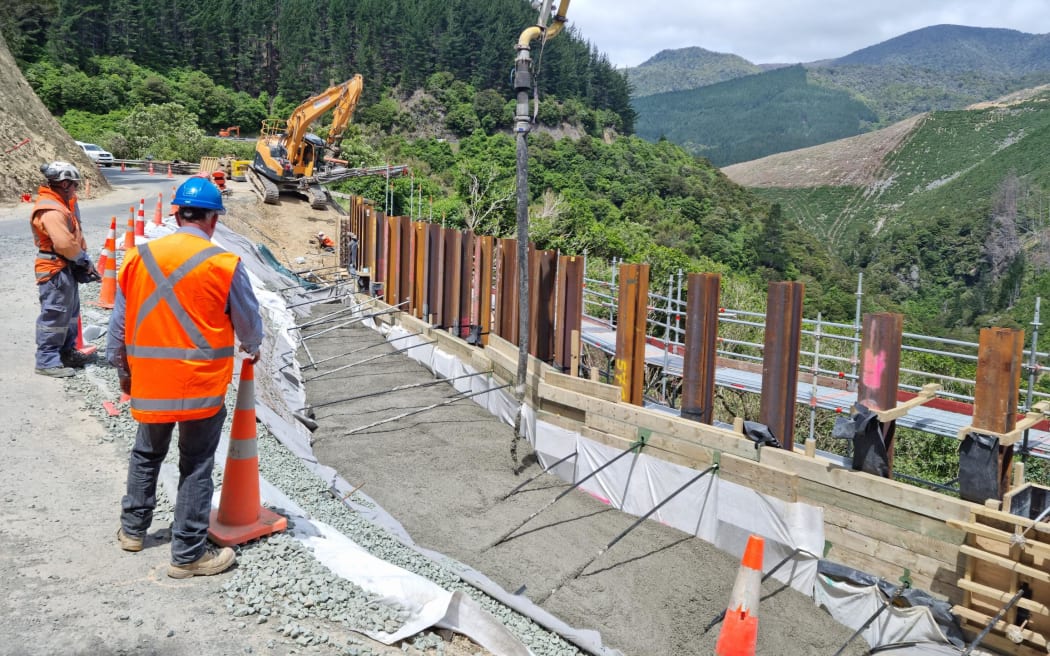 Concrete being poured behind a retaining wall and structural steel columns at site four, the most complex flood damaged site on SH6.