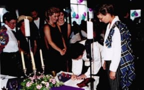An image of the couple signing the marriage register.