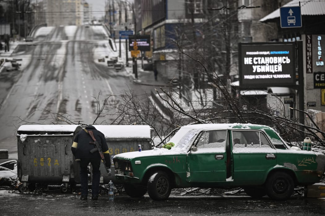 An armed man stands at a road block in downtown Kyiv on March 1, 2022.