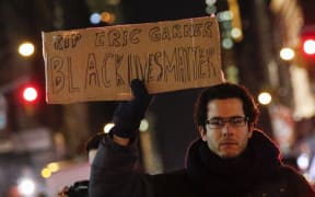 A protester in New York City holds a banner reading "Black Lives Matter" as he takes part in a rally over the death of Eric Garner.