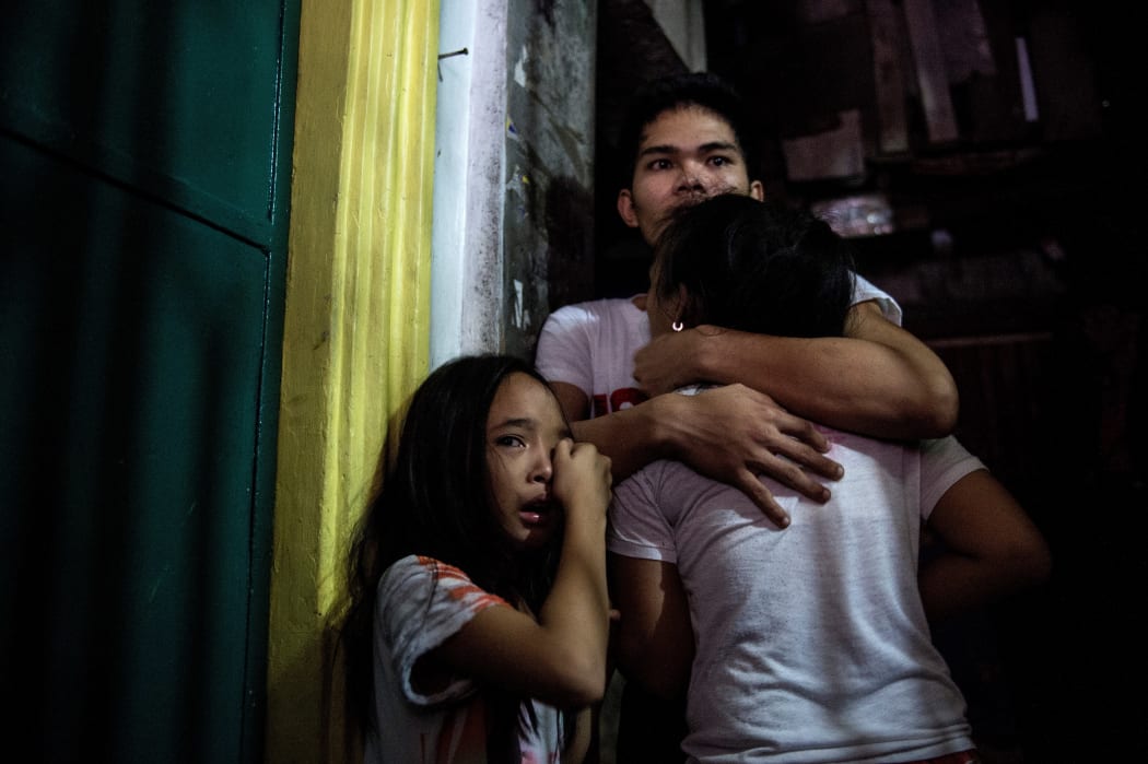 This picture taken on January 5, 2017, shows relatives crying as coroners carry the body of an alleged drug dealer killed during a drug buy bust operation in Manila.