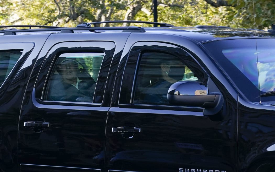 President Donald Trump watches from his Presidential state car as he returns to the White House after playing golf in Washington, DC.