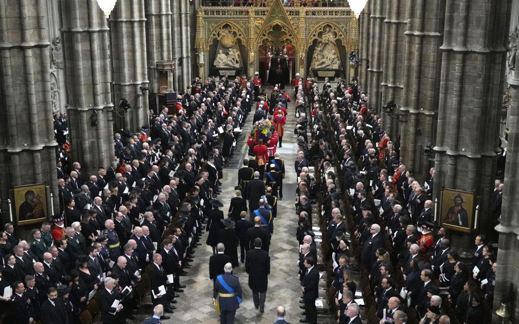 A Bearer Party of The Queen's Company, 1st Battalion Grenadier Guards carries the coffin of Queen Elizabeth II, draped in the Royal Standard, from the State Gun Carriage of the Royal Navy into Westminster Abbey in London on September 19, 2022, during of the State Funeral Service.