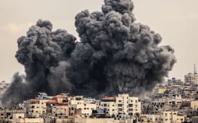A plume of smoke rises in the sky of Gaza City during an Israeli airstrike on October 9, 2023. Israel relentlessly pounded the Gaza Strip overnight and into October 9 as fighting with Hamas continued around the Gaza Strip, as the death toll from the war against the Palestinian militants surged above 1,100.