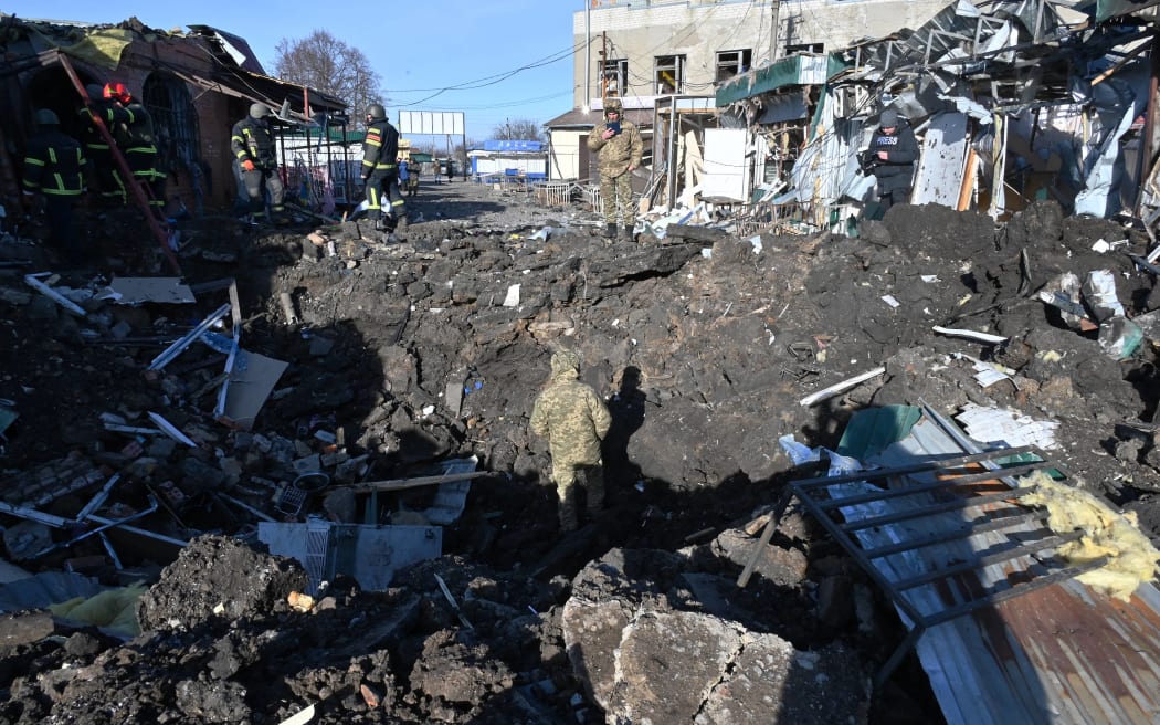 Rescatistas ucranianos trabajan en el sitio luego de un ataque con misiles rusos en un mercado local en el pueblo de Shevchenkove, región de Kharkiv.