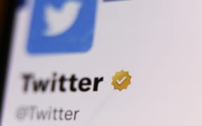 The gold checkmark on Twitter account on Twitter is seen displayed on a phone screen in this illustration photo taken in Krakow, Poland on February 14, 2023 (Photo by Jakub Porzycki/NurPhoto) (Photo by Jakub Porzycki / NurPhoto / NurPhoto via AFP)