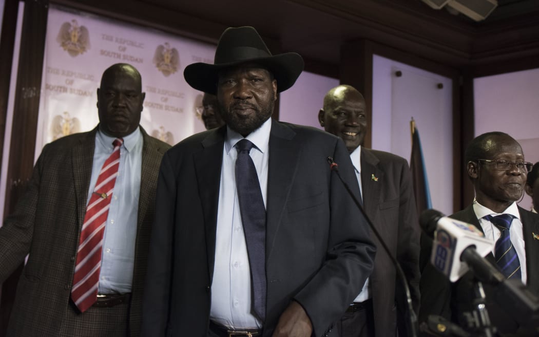 South Sudan President Salva Kiir (C), followed by Vice President James Wani Igga (2nd R), leaves the conference room as artillery fire broke out near the presidential palace in Juba