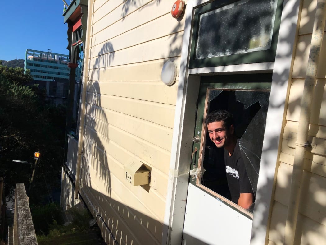 Student Sam Jarnie at his flat in Wellington that may have a smashed window but still has a great view.