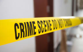 crime scene tape in front of room door with blurred background