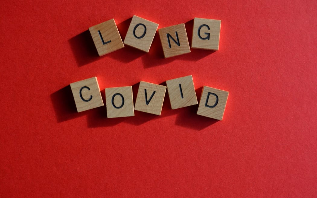 Long Covid, words in wooden alphabet letters isolated on bright red background with copy space
