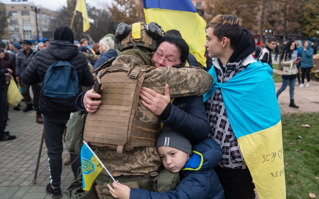 Local residents hug a Ukrainian soldier as they celebrate the liberation of Kherson, on November 14.