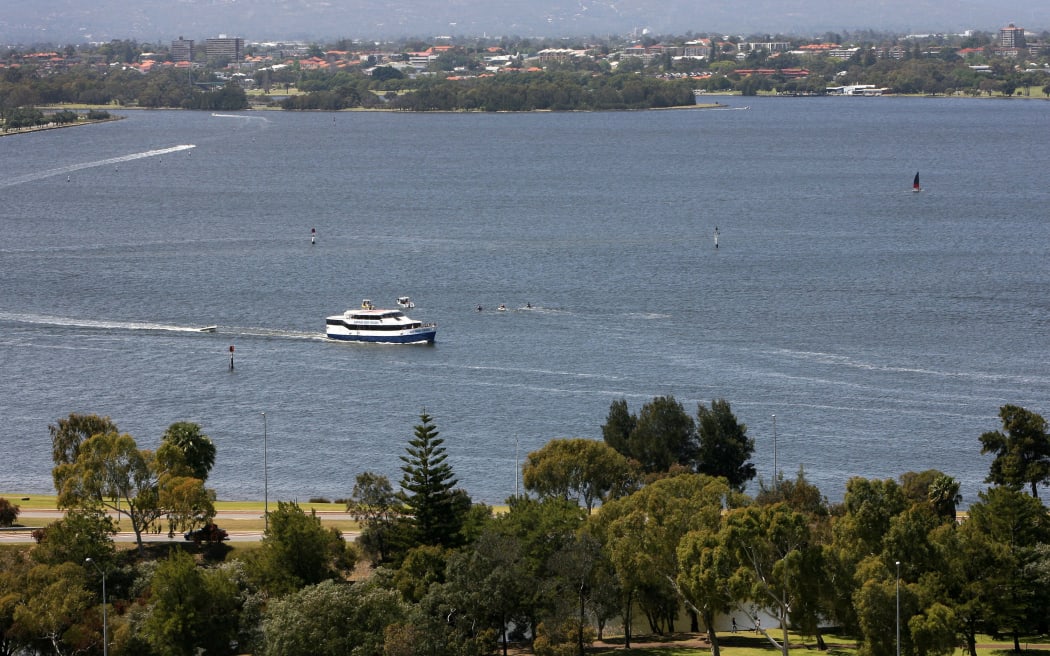 A boat (C) cruises on Perth's Swan River with the Darling Ranges (top), 15 October 2006.