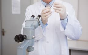 man in lab coat and microscope