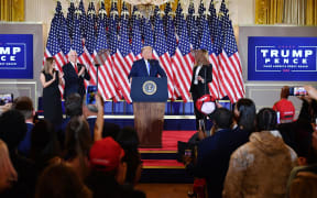 US President Donald Trump, flanked by Karen Pence (L), US Vice President Mike Pence (2nd L) and US First Lady Melania Trump (R), speaks during election night in the East Room of the White House in Washington, DC, early on November 4, 2020.