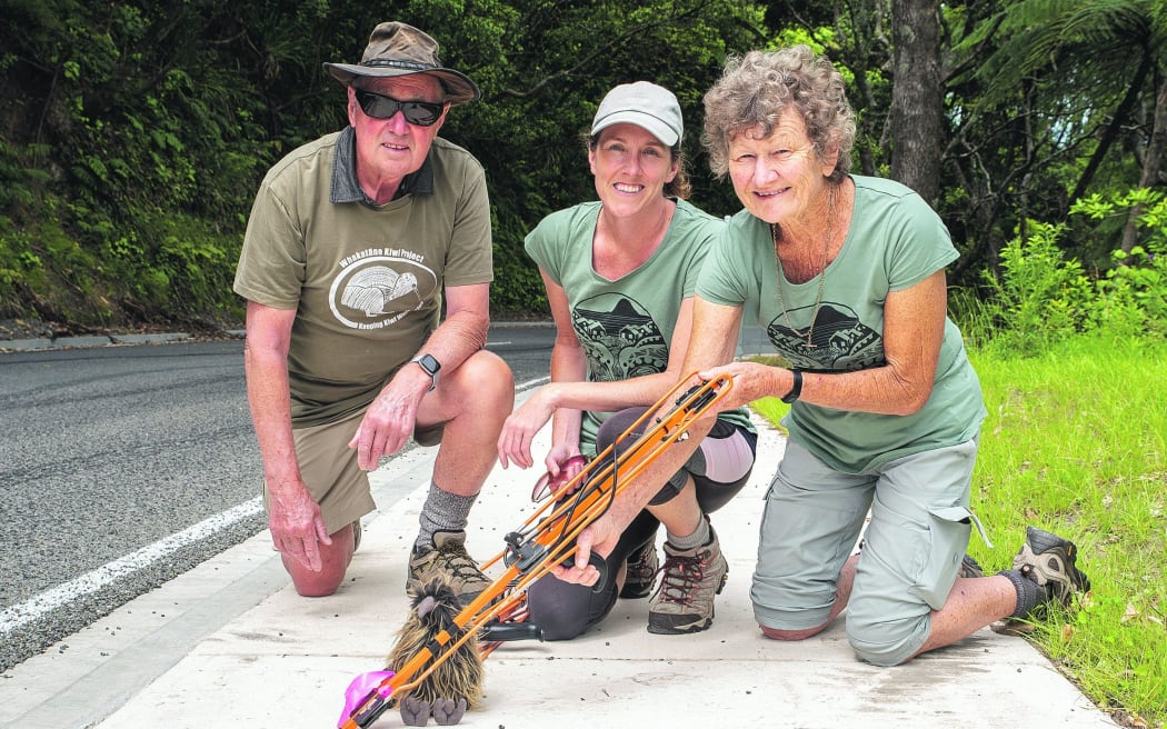 Kiwi Trust volunteers Ken and Sue Laurent with marketing and funding co-ordinator Hilary Sheaff point out the footprints with one of their kiwi monitoring aerials.