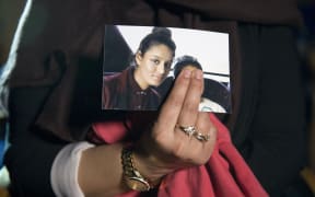In this file photo taken on February 22, 2015 Renu Begum, eldest sister of missing British girl Shamima Begum, holds a picture of her sister while being interviewed by the media in central London