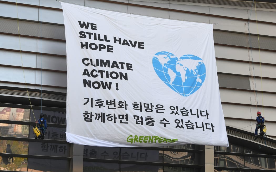 Greenpeace activists display banner reading "We still have hope, Climate action now!" prior to a press conference of the Intergovernmental Panel for Climate Change (IPCC) at Songdo Convensia in Incheon on October 8, 2018.