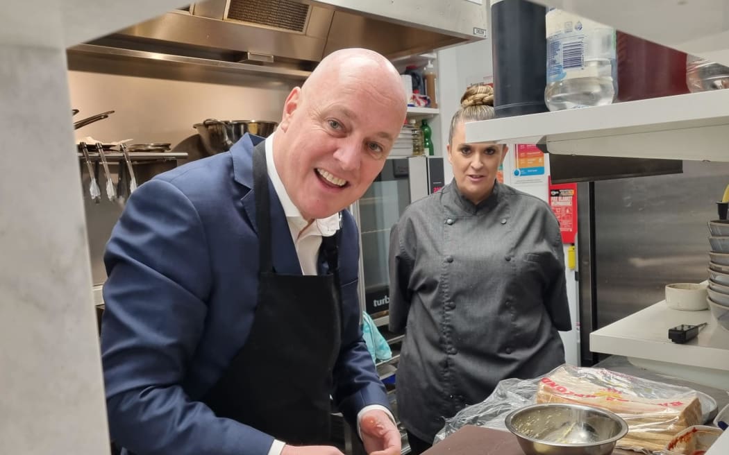 National Party leader Christopher Luxon makes cheese rolls at Majestic Tea Bar in Invercargill on 21 September 2023 while on the campaign trail.