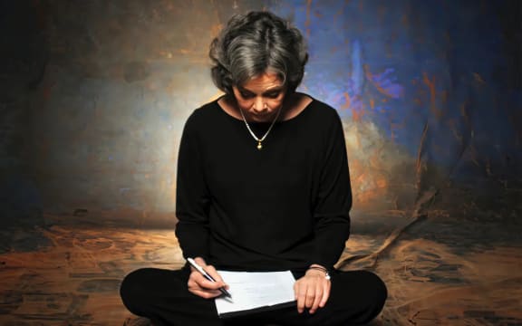 Cover image from the tribute album to American singer-songwriter Nancy Griffith, 'More than a Whisper'. Griffith sits cross-legged with pen and paper in hand.